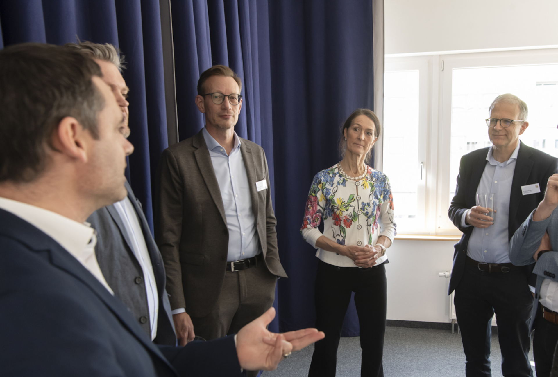 Teilnehmende der TOP JOB-Insights in Heilbronn im Gespräch vor einem blauen Vorhang